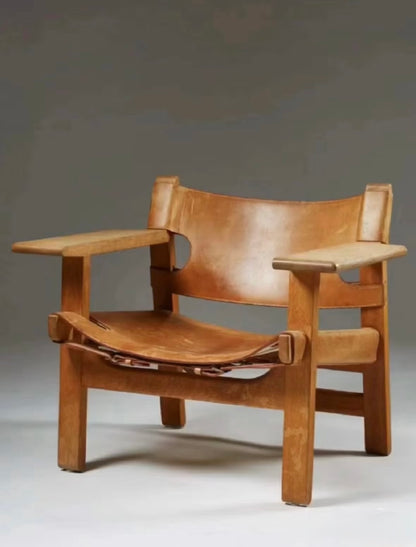 Front view of The Spanish Chair in Teak wood with tan leather sling seat and backrest.