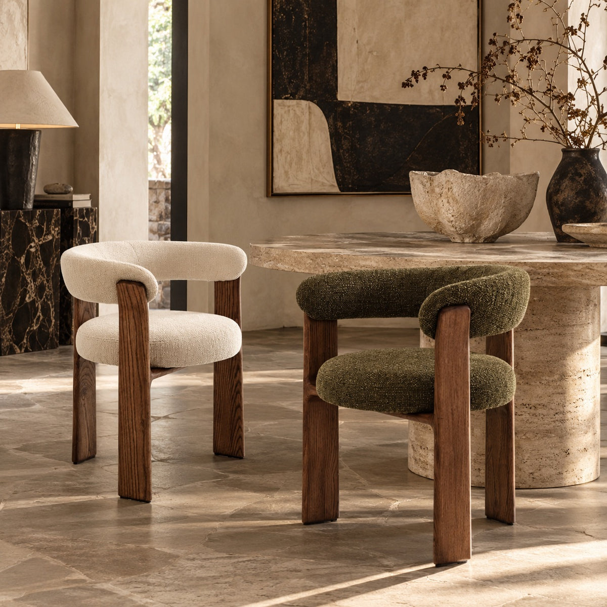 Ivory cream and olive green sculptural curved back dining chairs with walnut-tone wood frames around a travertine dining table