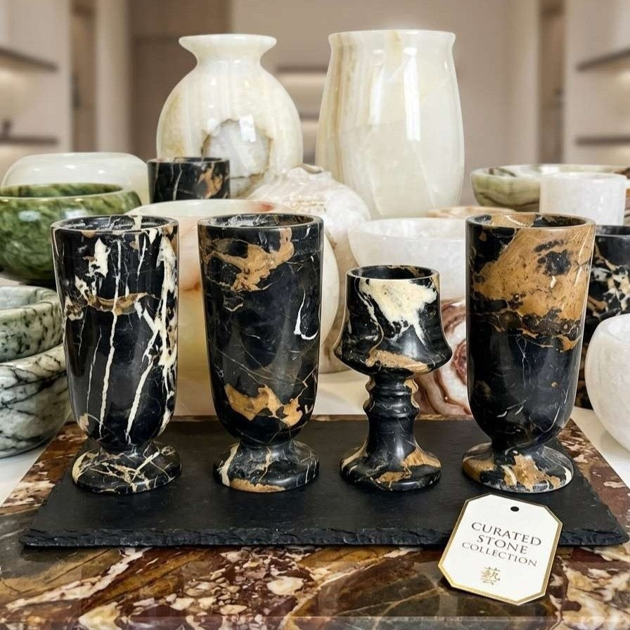 Marble-patterned cups on a dark surface with a 'Curated Stone Collection' tag in a blurred background.