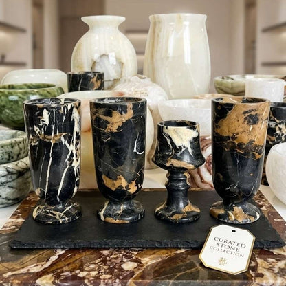 Marble-patterned cups on a dark surface with a 'Curated Stone Collection' tag in a blurred background.