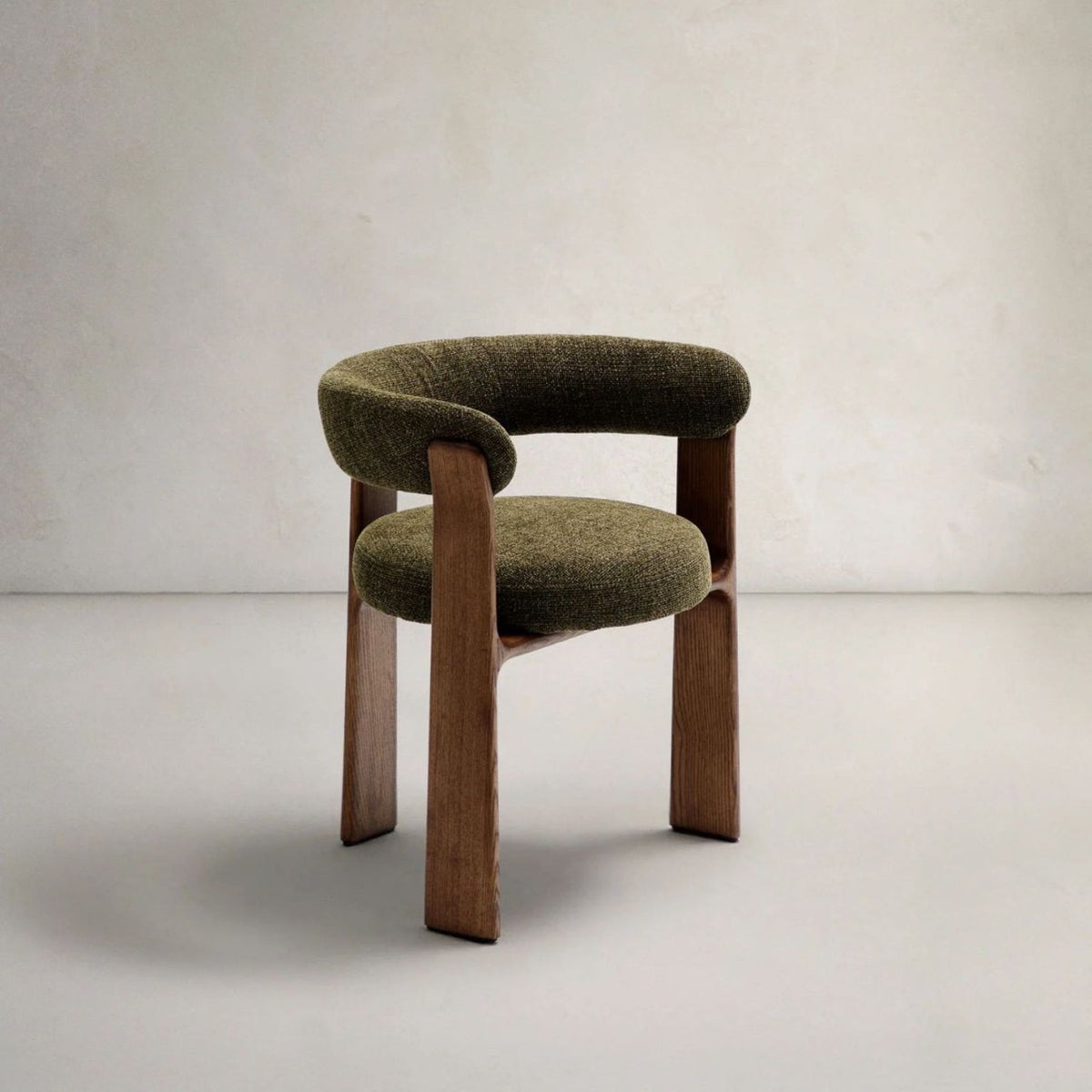 Olive green sculptural dining chair with textured upholstery and curved wooden frame