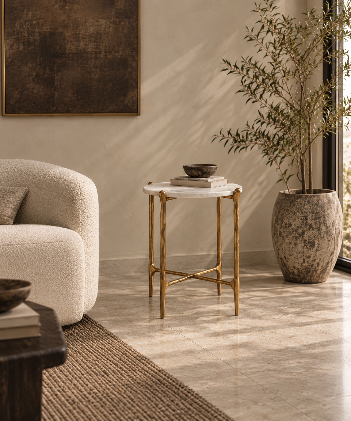 Ausi round marble and gold side table beside cream boucle chair