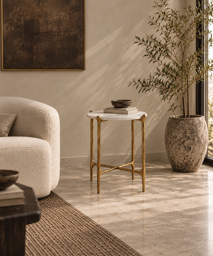 Ausi round marble and gold side table beside cream boucle chair