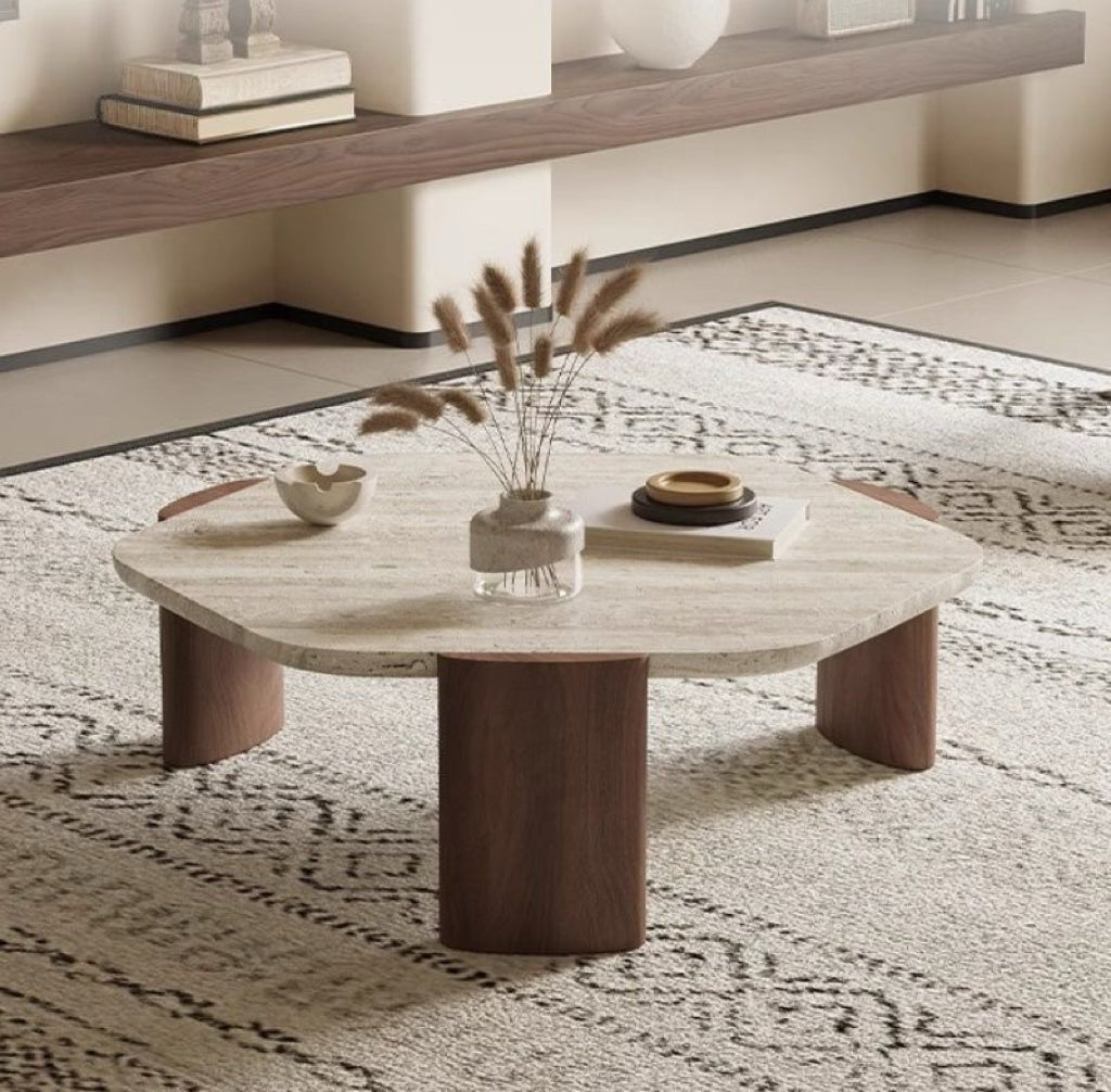 Wooden coffee table with decorative items on a patterned rug in a living room.