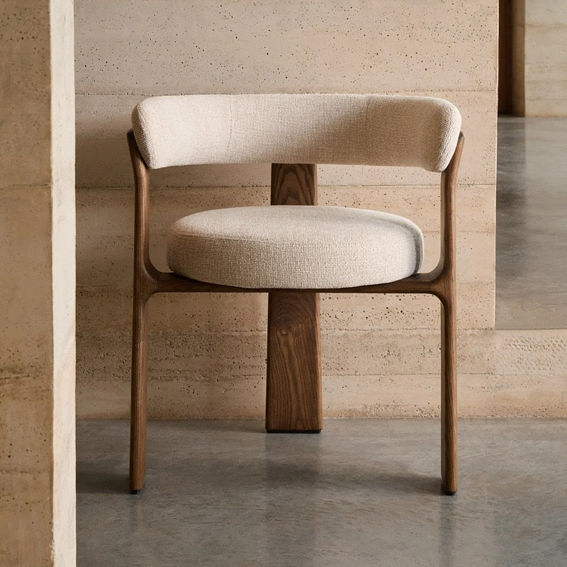 Front view of ivory cream sculptural curved back dining chair with walnut-tone ash wood frame