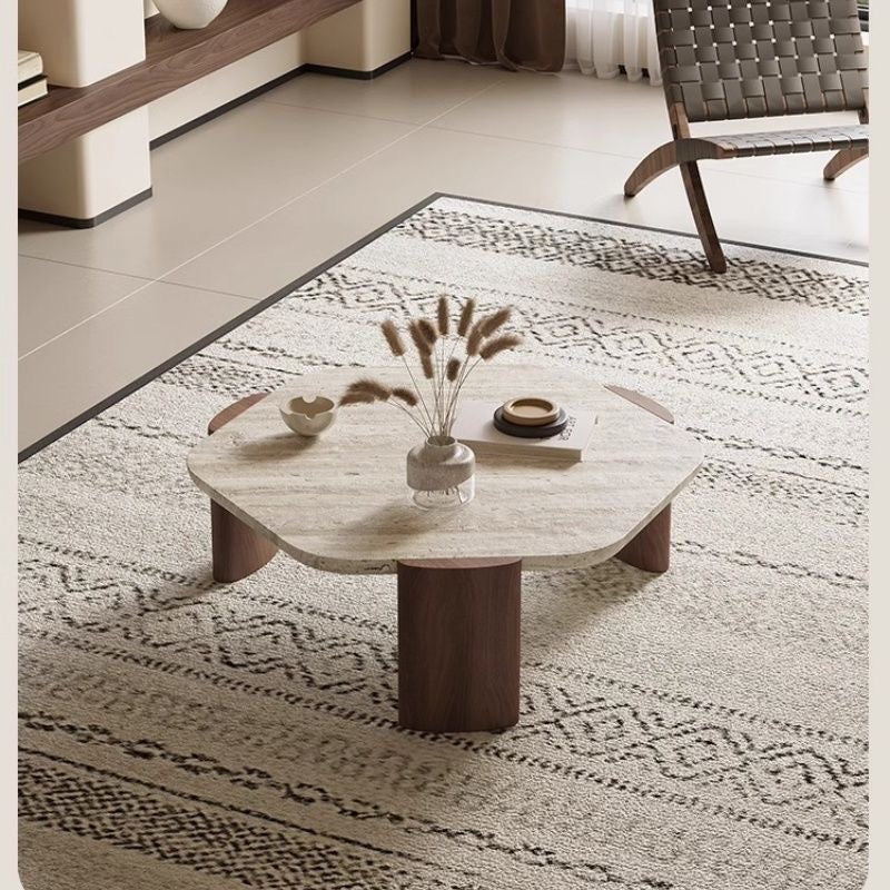 Coffee table with decorative items on a patterned rug in a living room setting