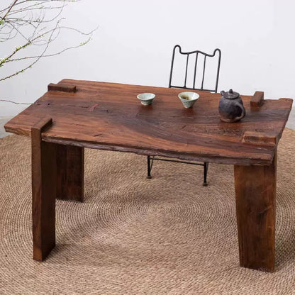 Rustic handcrafted solid wood artisan table with natural wood grain and exposed joinery styled in an organic modern interior.