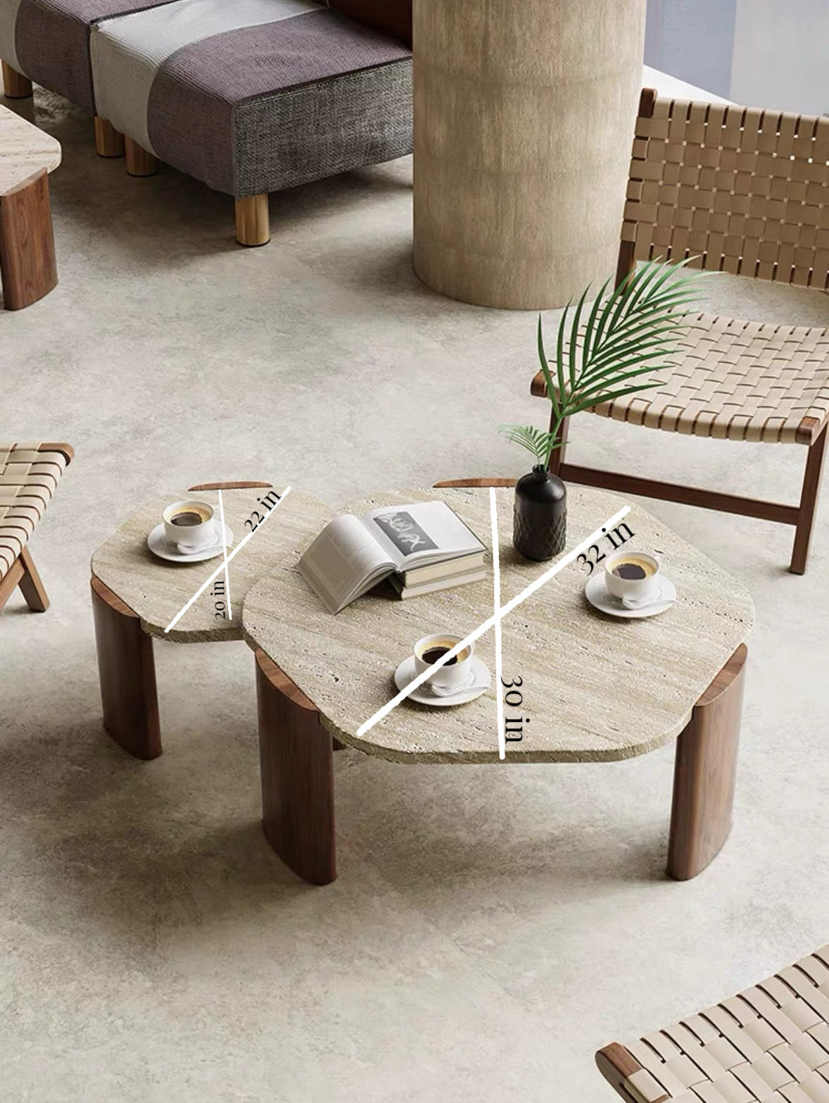 Coffee table with books, cups, and a plant in a modern living room setting.