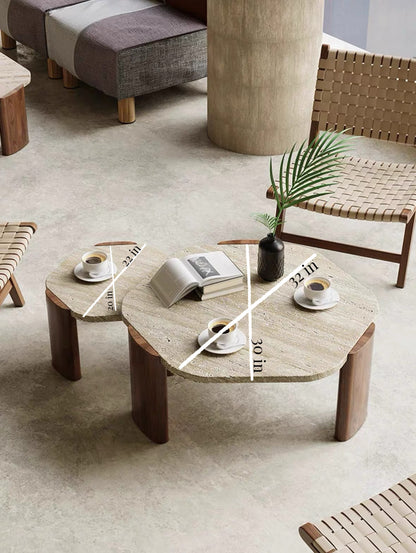 Coffee table with books, cups, and a plant in a modern living room setting.