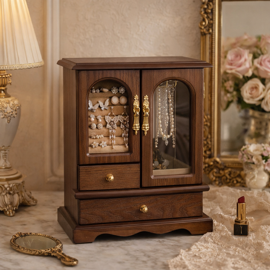 Wooden jewelry cabinet with glass doors displaying jewelry, next to a lamp and decorative items.
