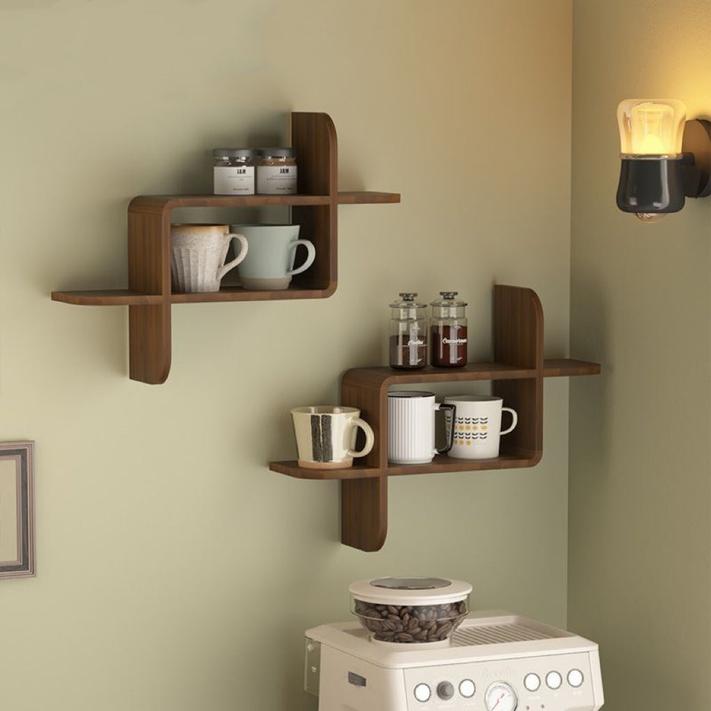 Wooden wall shelves with cups and jars against a light green wall.